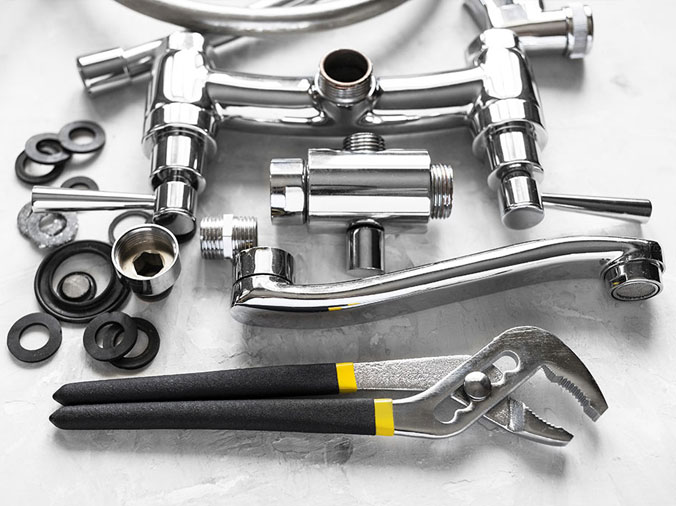 disassembled kitchn sink faucet with plumbing plyers